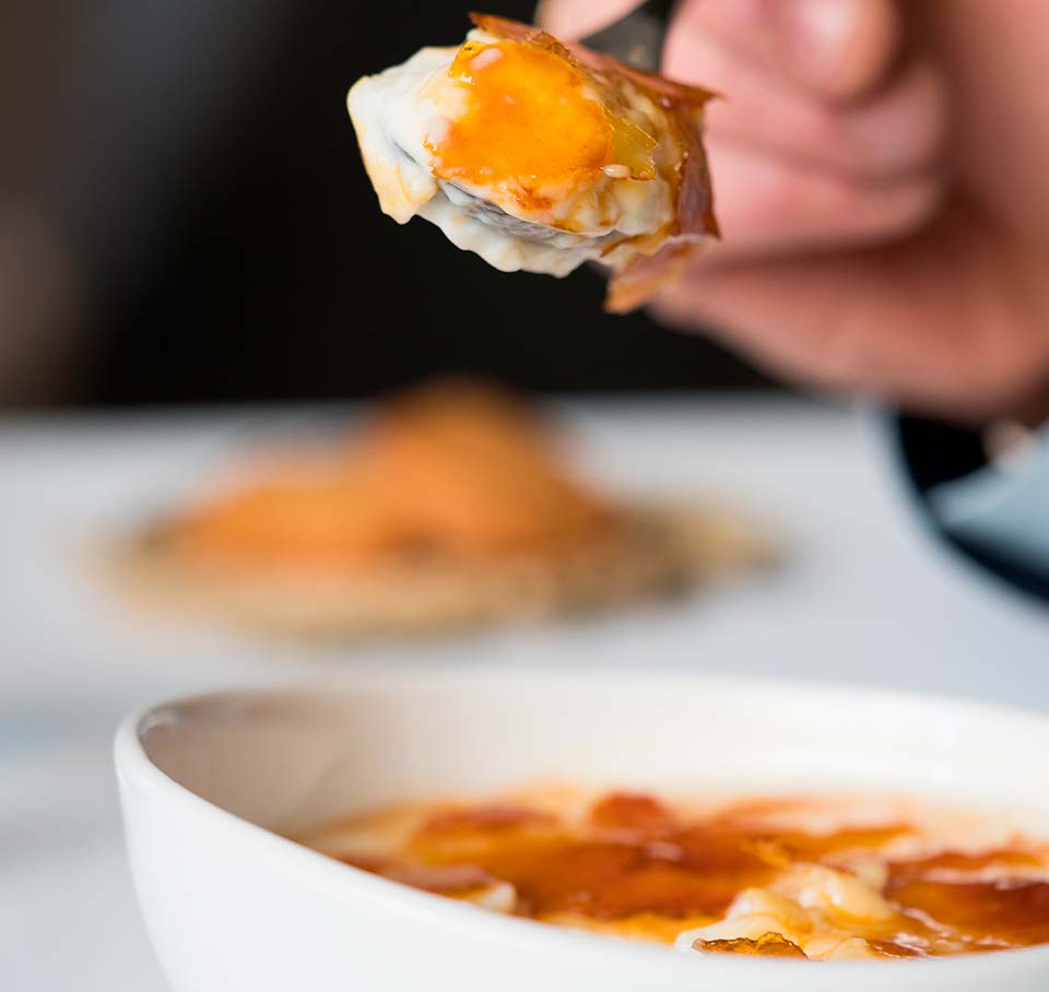 Arroz con leche cremoso con costra quemada, el postre típico de la comida asturiana en Madrid.